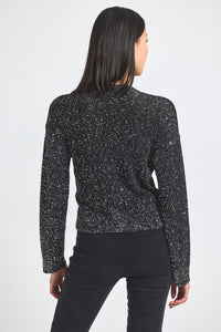 Person wearing a black speckled jacket on a white background