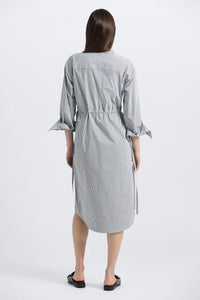 Woman wearing a gray striped dress on a white background