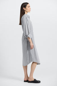 Woman wearing a gray checkered dress on a white background