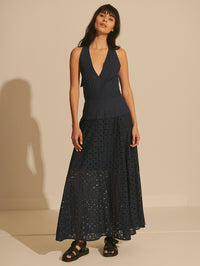 Woman wearing a dark blue dress with a plain background