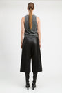 A model shown from the back wearing a gray sleeveless top, black wide-leg cropped pants, and black heeled boots against a plain light gray studio background.
