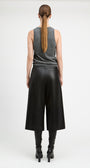 A model shown from the back wearing a gray sleeveless top, black wide-leg cropped pants, and black heeled boots against a plain light gray studio background.