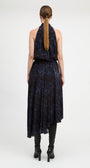 A woman viewed from the back wearing a sleeveless dark navy dress with a blue abstract print and black knee-high boots against a light gray studio background.
