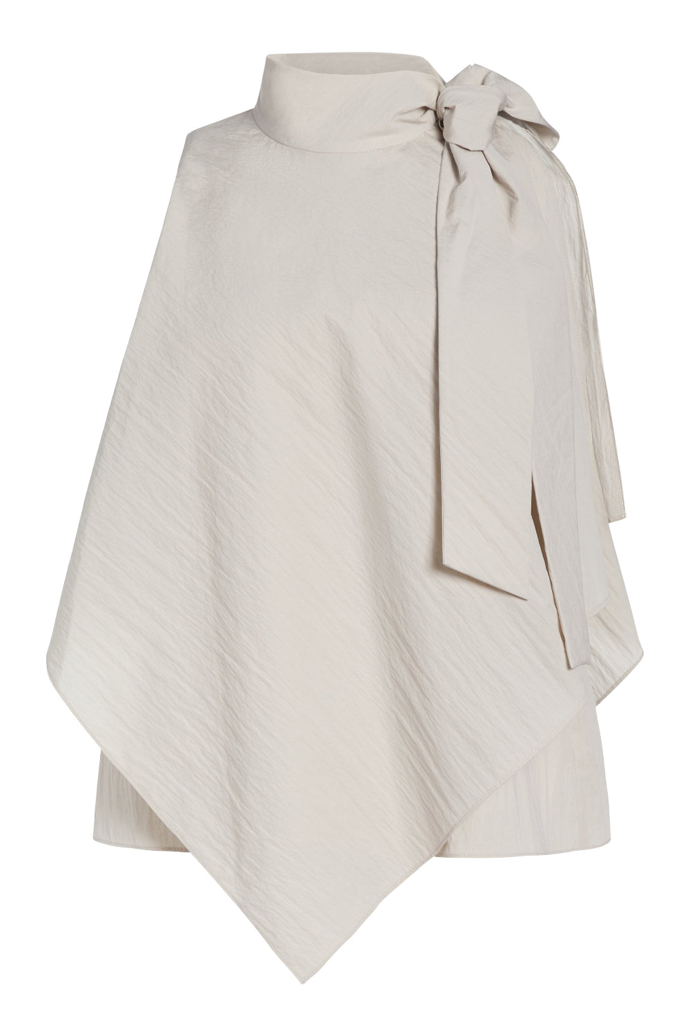 An asymmetrical cream-colored cape top with a high mock neck, textured diagonal crinkle pattern, and a large side bow detail, shown on a plain white background.