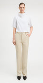Woman wearing straight cut parchment color jeans with white top.