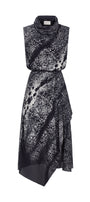 A sleeveless high-neck midi dress with an abstract black and white spotted pattern, featuring a wrap-style skirt and asymmetrical hemline, shown against a plain white background.