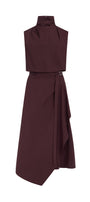 A sleeveless high-neck wrap dress in a deep burgundy color, featuring a structured top section and an asymmetrical draped skirt with a small belt buckle detail at the waist, shown against a plain white background.