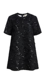 A black short-sleeve tunic dress with a textured, distressed lace-like pattern, shown against a plain white background.