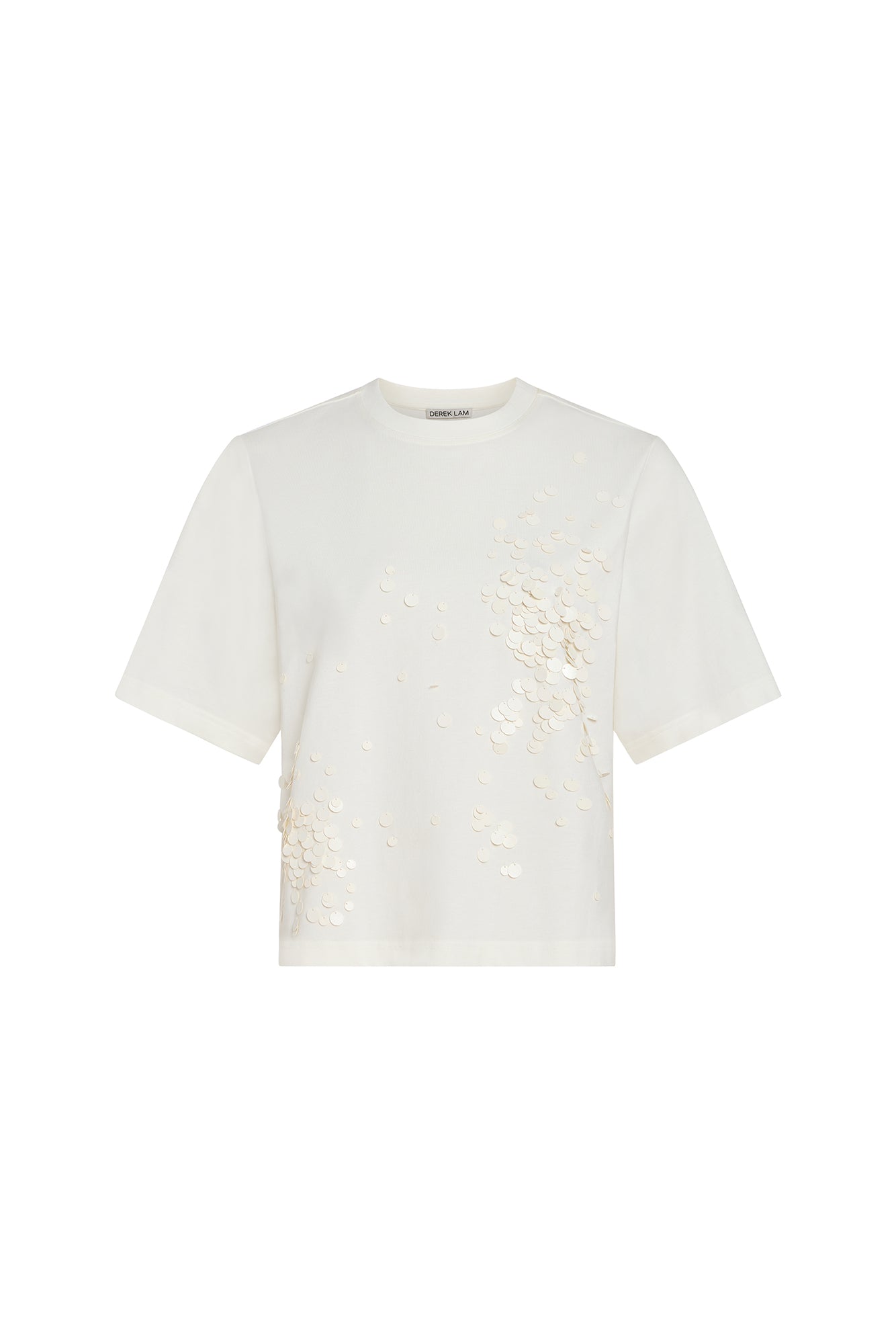 An off-white short-sleeve crop top by Comme des Garçons Paris, featuring textured 3D floral appliques on the front right side, displayed against a solid white background.