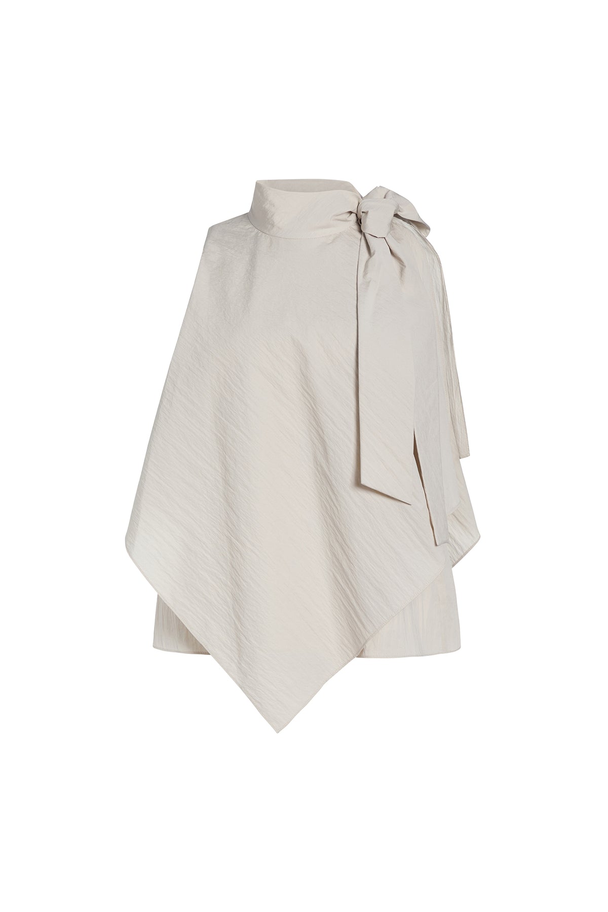 An asymmetrical cream-colored cape top with a high mock neck, textured diagonal crinkle pattern, and a large side bow detail, shown on a plain white background.
