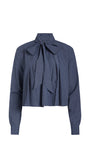 A cropped long-sleeve blouse with vertical navy and white stripes, featuring a large bow tie at the collar and a pleated front design, shown against a plain white background.