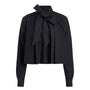 A black long-sleeve blouse with a high collar and a large bow tied at the front, shown on a plain white background.