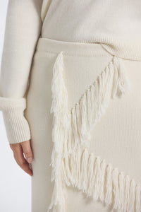 Close-up of a beige sweater with fringed hem on a white background