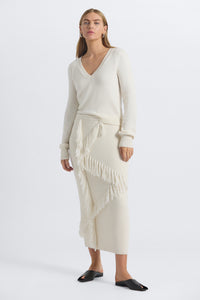 Woman wearing a white sweater and skirt on a white background