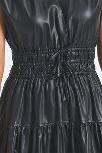 Black leather dress with a tie waist on a plain background