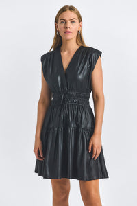 Woman wearing a black leather dress against a white background
