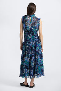 Woman wearing a sleeveless, floral-patterned dress on a white background