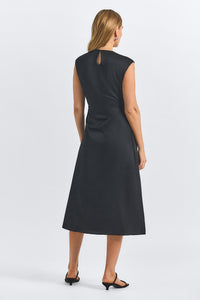 Black dress worn by a model on a white background