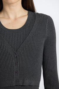 Close-up of a dark gray ribbed sweater with buttons on a white background
